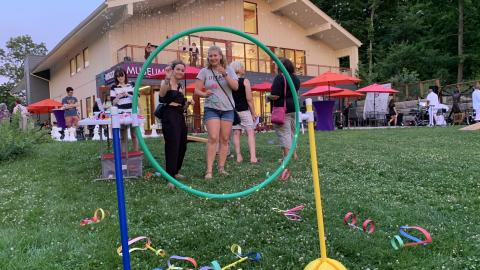 adults play a ring toss game outside