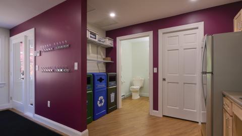 an interior view of a room with recycling bins and trash containers