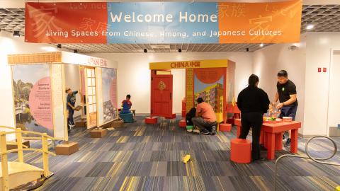 a pulled back view of a full museum gallery with a banner that reads, "Welcome Home"