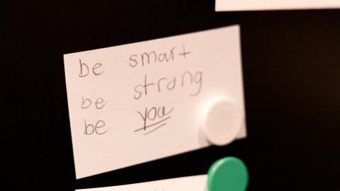 a piece of paper posted to a board says, "be smart be strong be you"