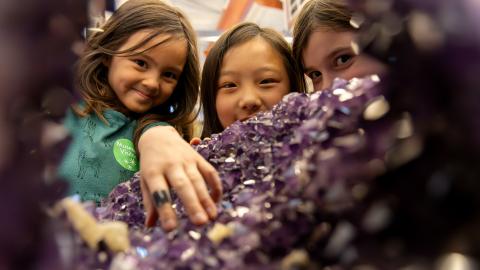 three girls explore a giant amethyst